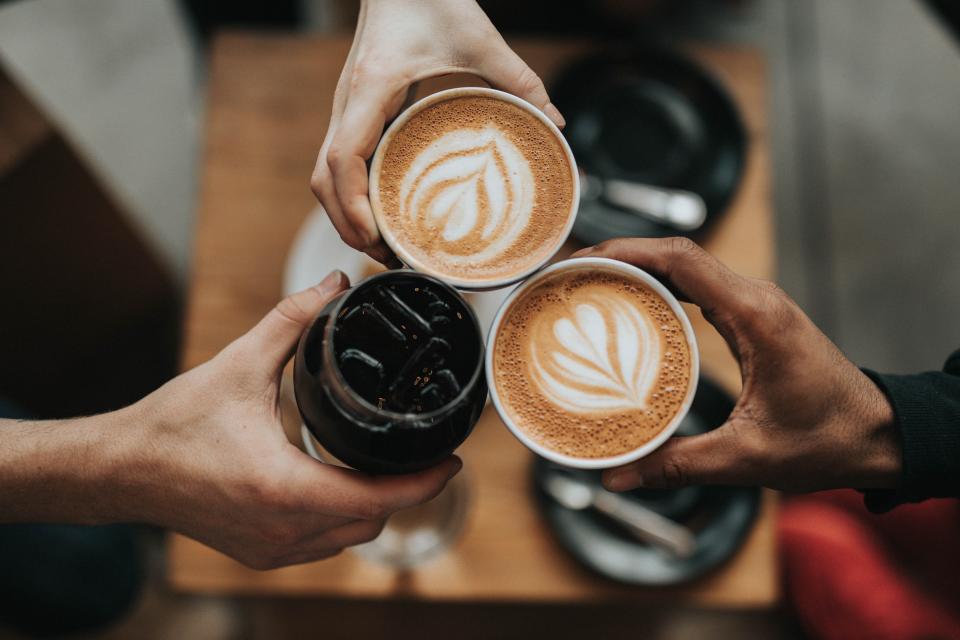 Twee koffiebekers die tegen elkaar tikken